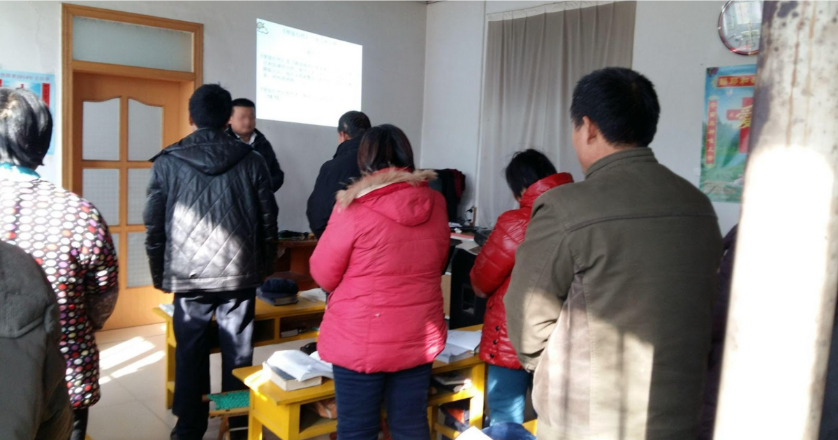 Underground church prayer meeting where student's father is leading the prayer